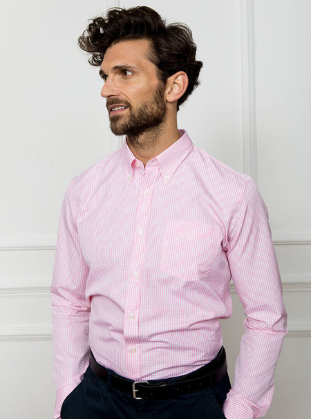 Man wearing a pale pink long sleeved shirt in a gingham pattern made with 100% cotton in a Thomas Mason fabric.